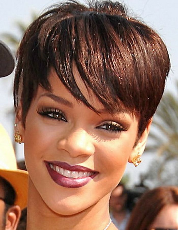 Rihanna, krótkie włosy, kuszący uśmiech, różowa szminka i złote kolczyki