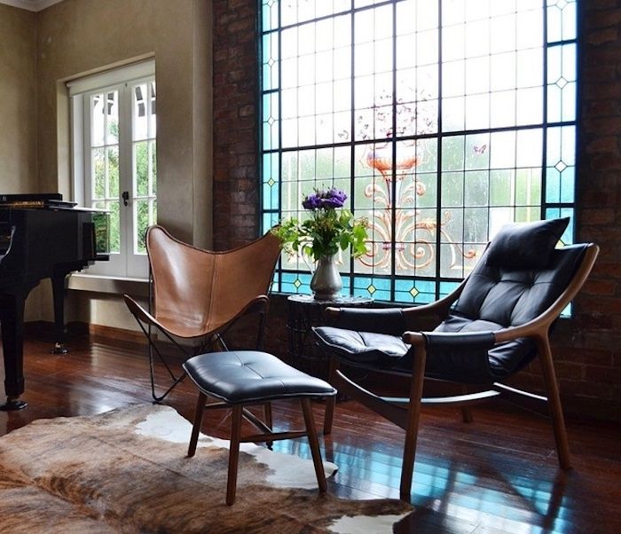 Stue med murvegg, firkantet vindu med vakkert glassmalerier, luksuriøse møbler