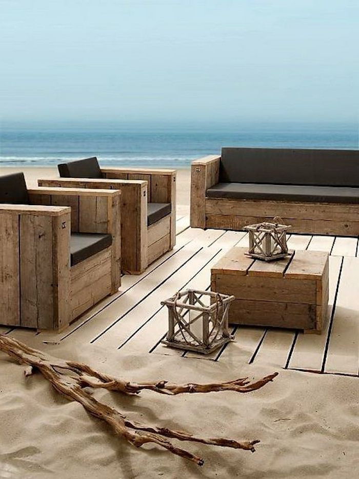 o plajă, nisip, o masă mică și canapele moderne din europaleți vechi - idee pentru terasa de mobilier pentru paleți