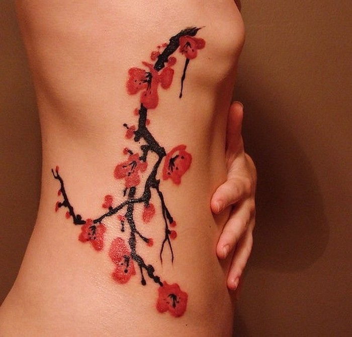 symbool van kracht, tak met rode kersenbloesems aan de lichaamszijde, tatoeages voor vrouwen