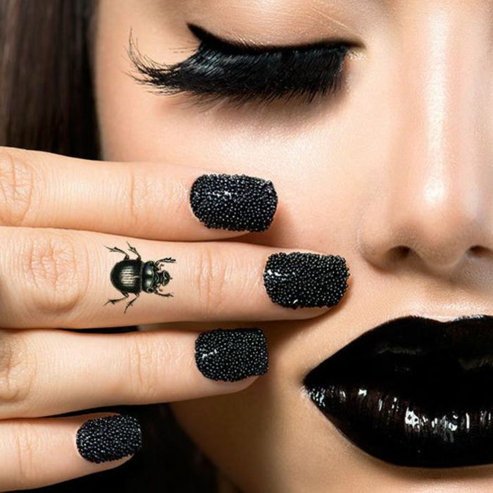 Motivo de tatuagem mulher deco no design de unha de besouro de dedos com pedras preto lábios cílios