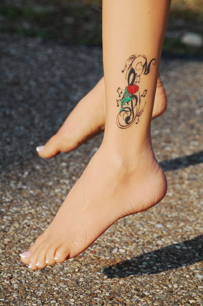 tatuaggio sulla caviglia, motivi femminili del tatuaggio, note musicali, note, tatuaggio delle gambe