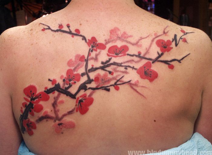symbool van gezondheid, takken met rode kersenbloesems, grote tatoeage op de rug