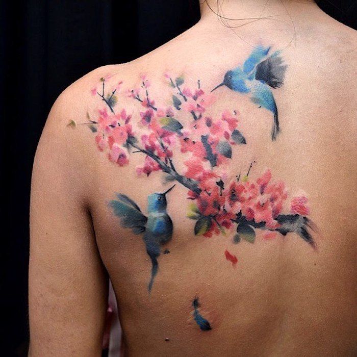 tatoeage kersenbloesems, rug tattoo, blauwe vogels in combinatie met takje met bloemen