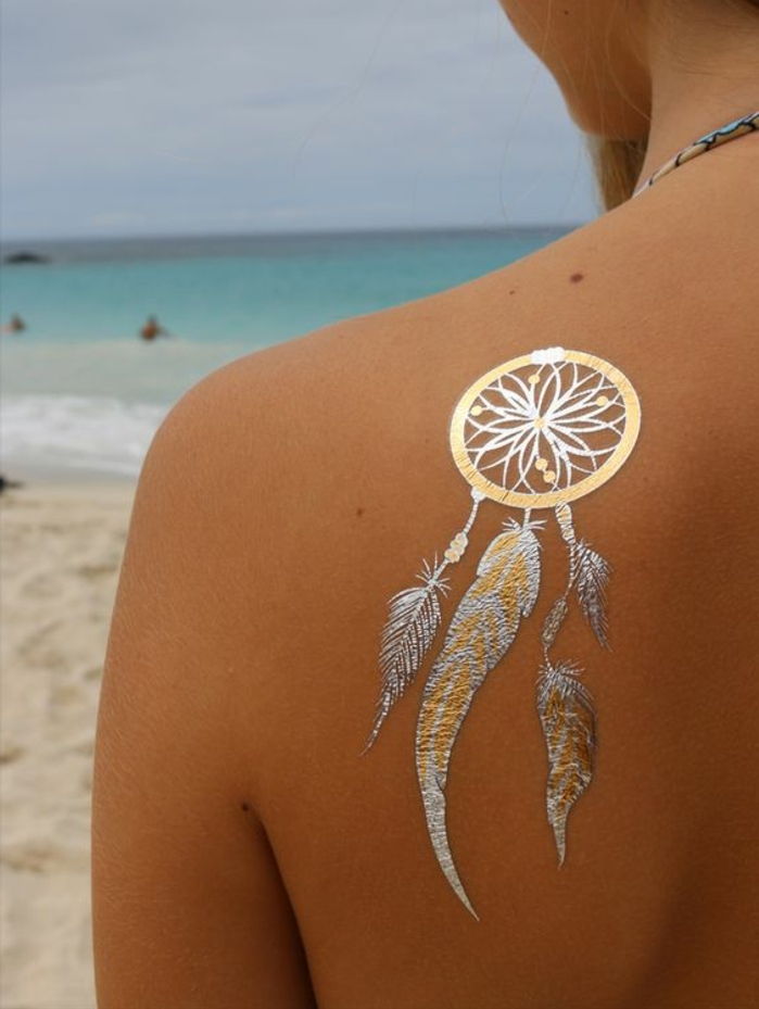 mulher de ombro de tatuagem idéias de dreamcatcher em prata e ouro mar mar ambiente cinza com maiô