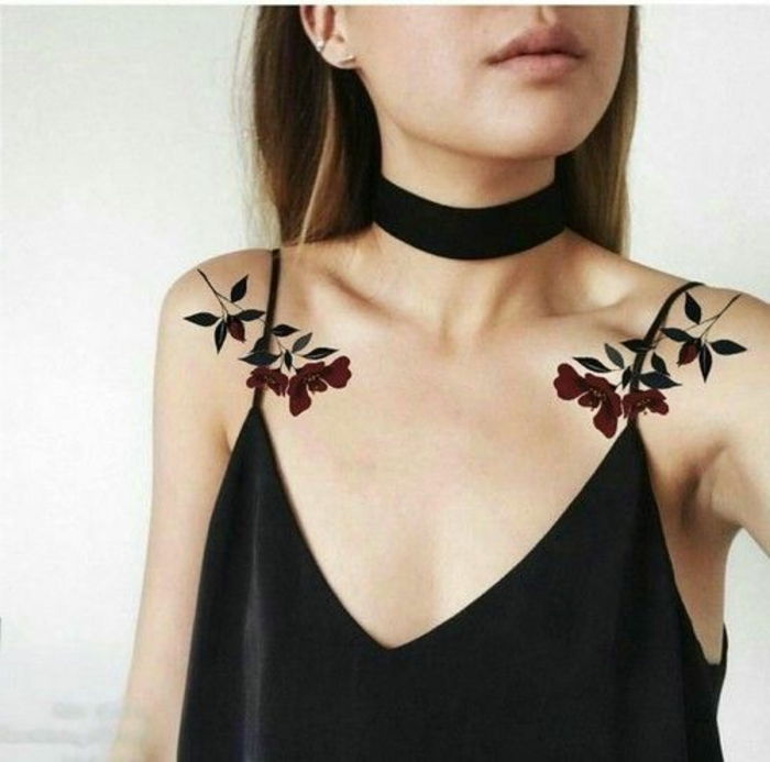 Duas tatuagens de mulher nos dois ombros de brincos de top preto de uma mulher flor