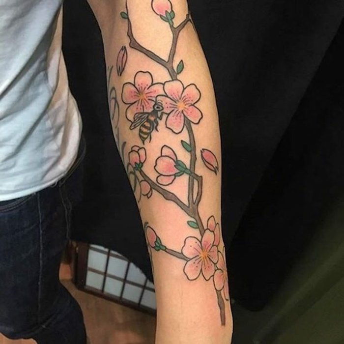 tatoeages met betekenis, tak met roze bloemen op de arm, tattoo onderarm