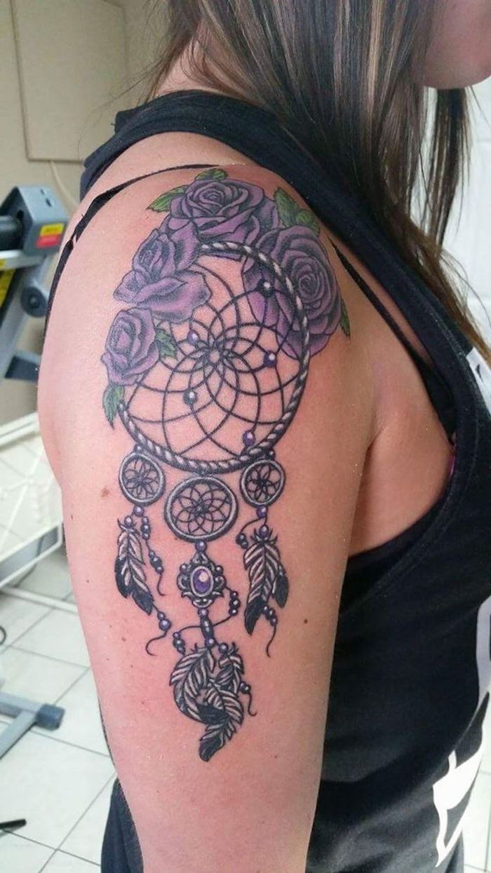 O idee pentru un tatuaj pe umărul unei femei cu trandafiri roșii violet și un captator de vis cu pene