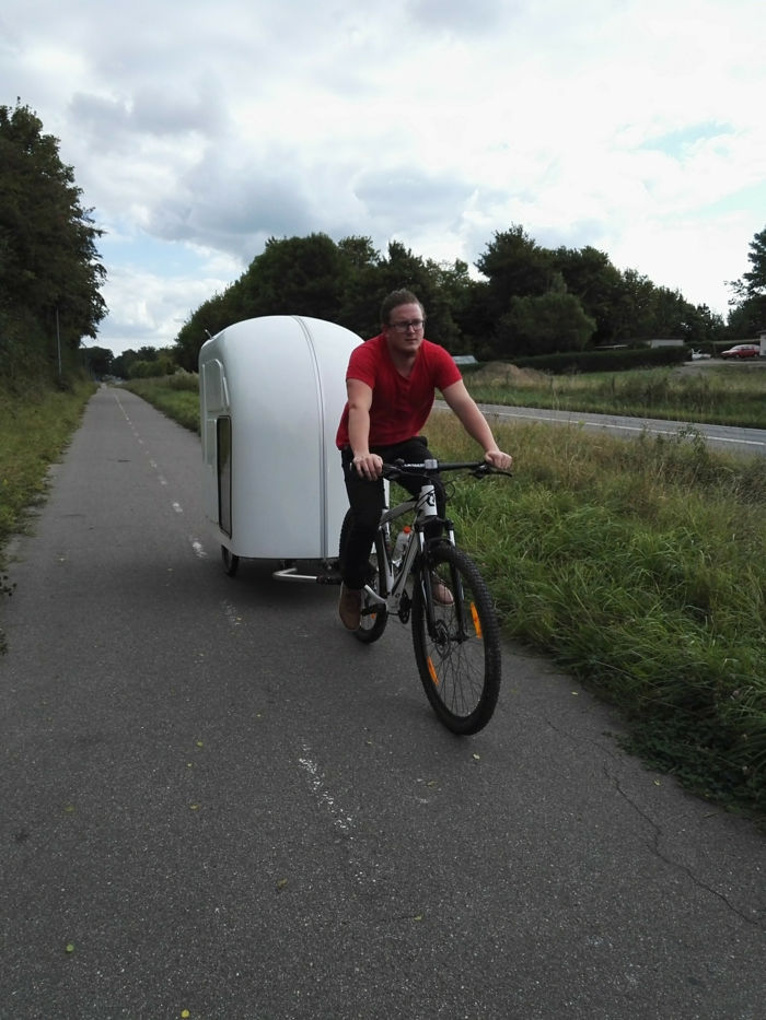 her er en syklist på vei med en hvit sykkelvogn