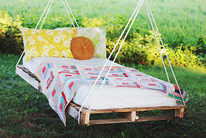un pat de agățat din europaleți vechi cu perne - idee pe tema mobilierului pentru grădină