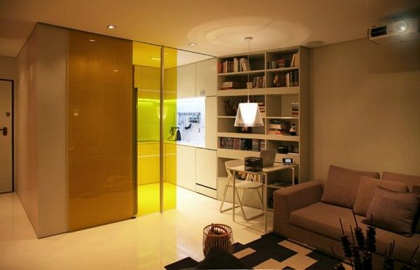 hem-för-små-lägenhet-en glasvägg skiljer vardagsrummet från köket