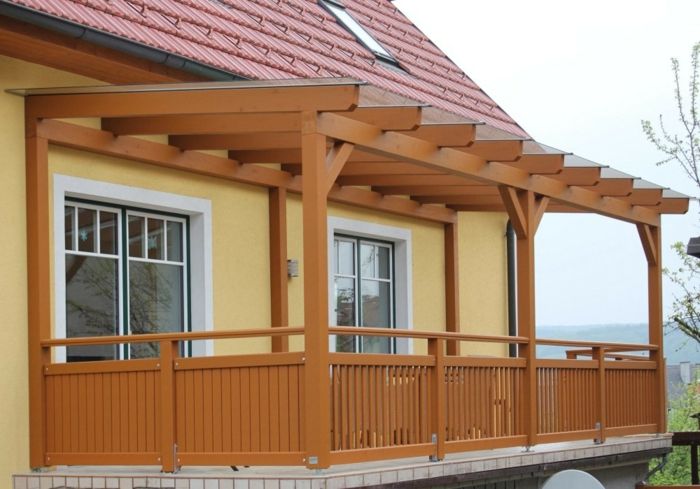 Terras dakbedekking hout bruin glazuur balkon idee gele gevel