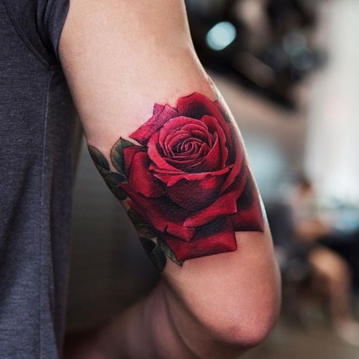 Žmogus su spalvotomis gėlėmis, tatuiruotė, didelė raudona rožė ant jo viršutinės rankos
