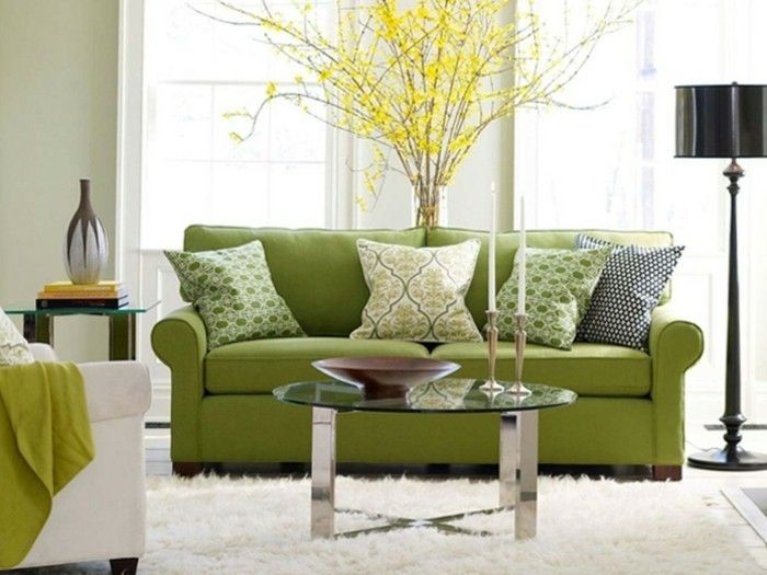 1farbgestaltung vardagsrum-soffa-in-grön-kudde-musterbezuege-gul-anläggning-vit-matta runt glas bords ljus-stol och vitt golvlampa Vase