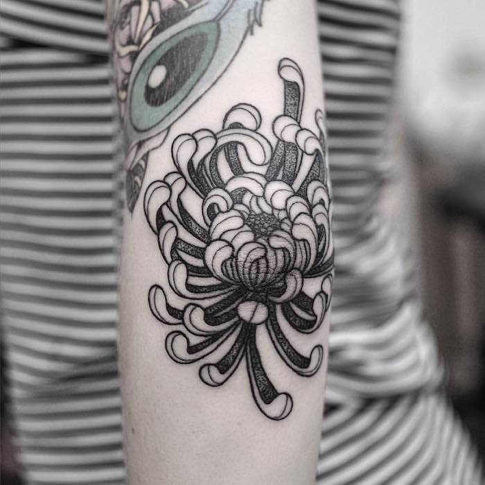 Tatuiruotes reiškia moteris su chrizantemos tatuiruotėmis juodoje ir pilkoje