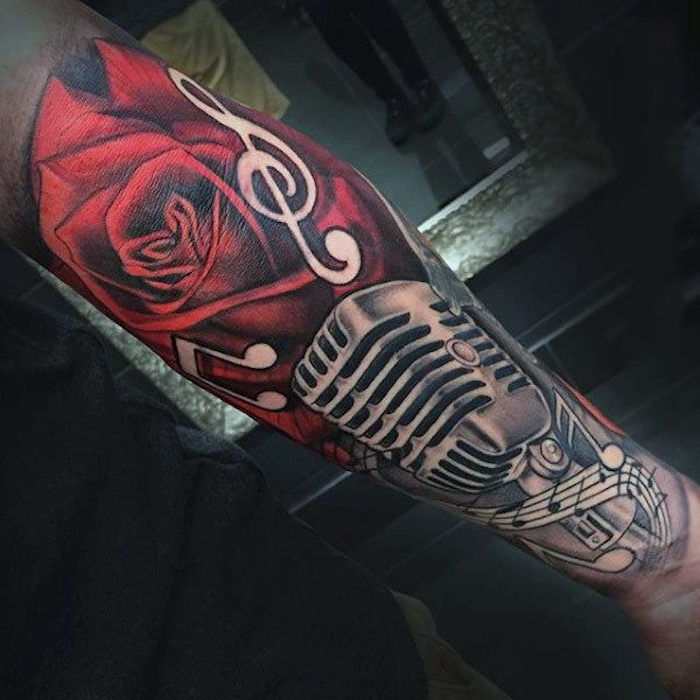 Tatuiruotės prasmė, rankovių tatuiruotė su raudonomis rožėmis, mikrofonu ir pastabomis