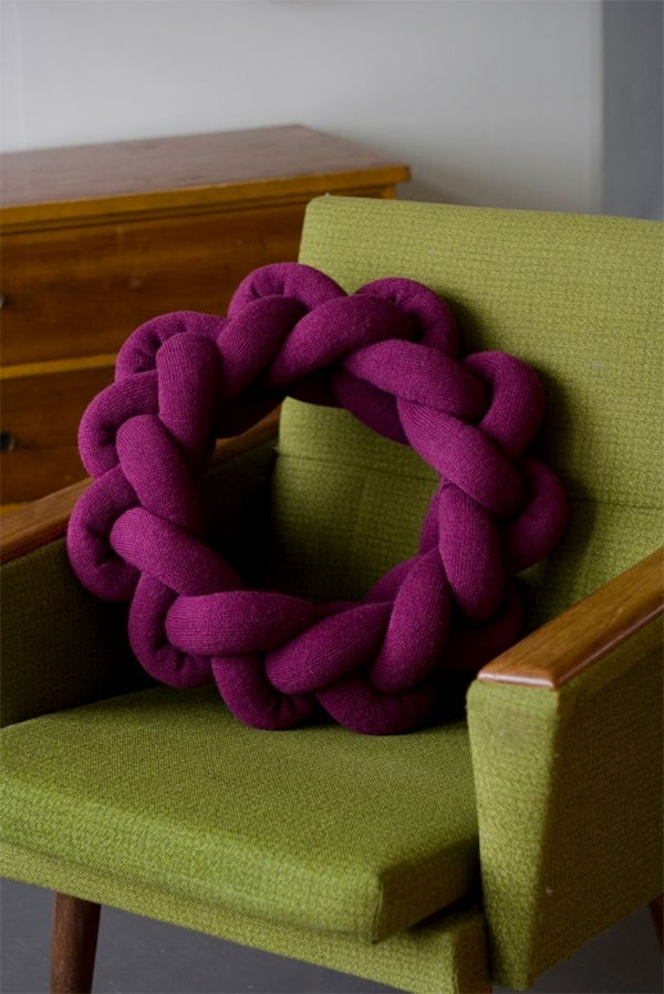 Purpurinė apvali sėdynių pagalvė.