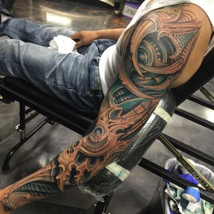 Biomechanikos tatuiruotė visoje rankoje, žmogus su biomechanine tatuiruotė