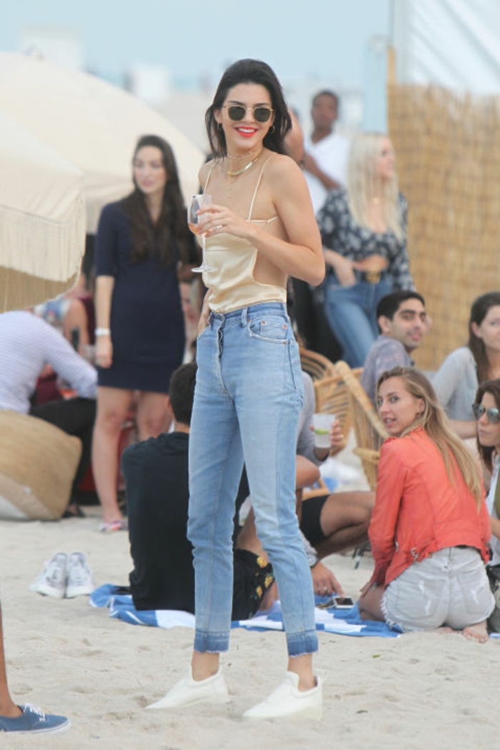 Paplūdimio apranga, Kendall Jenner, šviesios spalvos džinsiniai džinsai, baltos sportbačiai, viršuje su šampano spagečių diržais