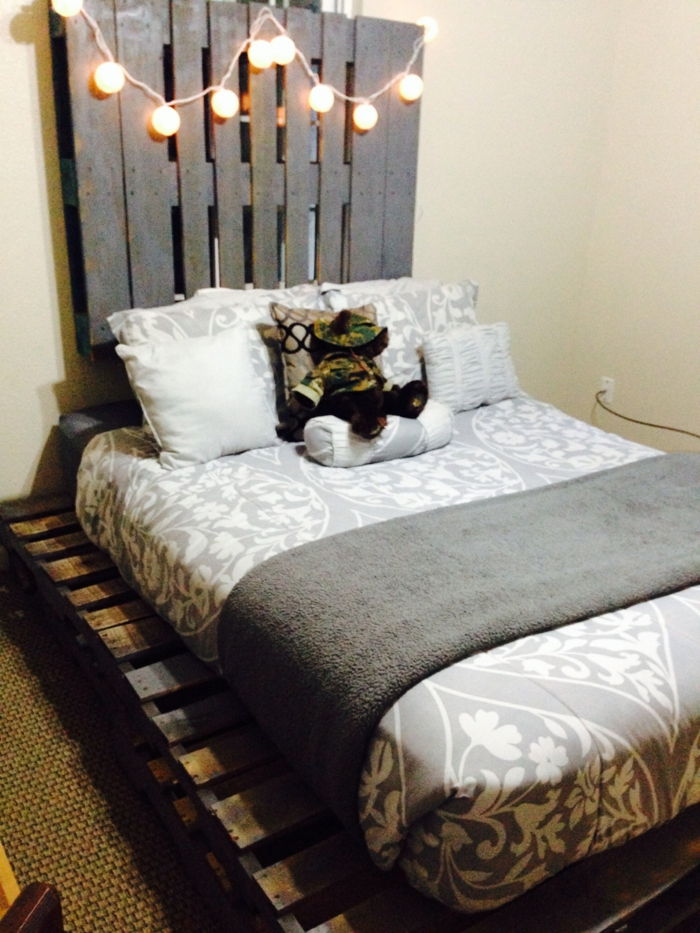 Huvudgavel säng från pallar hängande glödlampor-simple-sovrum-interiör grå filt