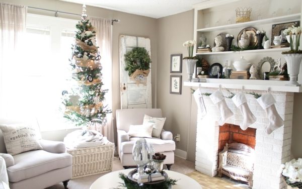 białe świąteczne dekoracje - w salonie z ładnym kominkiem i białą kanapą