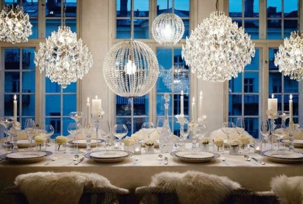 białe świąteczne dekoracje - stół jadalny i wiele kryształowych żyrandoli powyżej