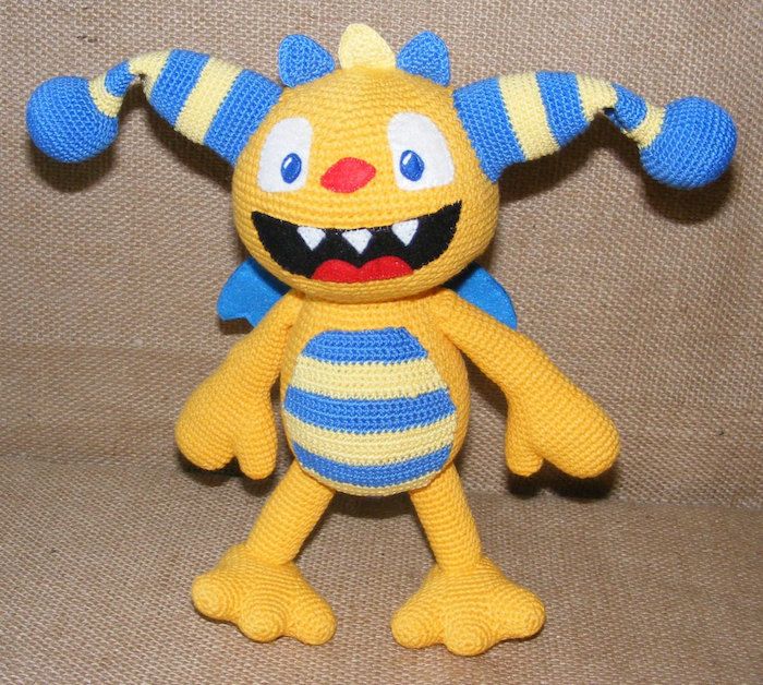 criatura estranha na cor amarela e azul com a boca aberta - encantos de boa sorte de crochê