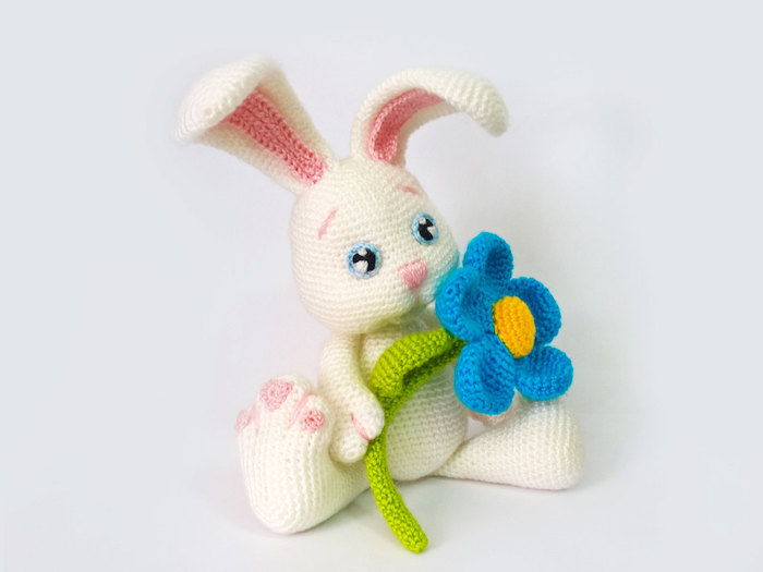 fazer crochê para a Páscoa, um coelhinho da Páscoa na cor branca com uma flor azul