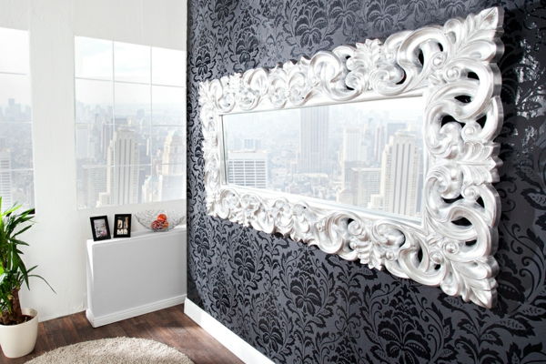 Baroko veidrodis su sidabro rėmeliu ant juodos sienos, gražus butas