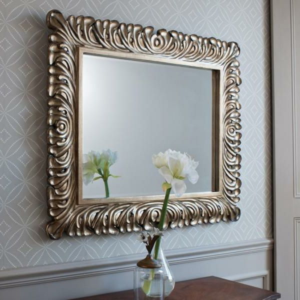 baroko veidrodis su sidabro rėmeliu - priešais jį baltoji gėlė