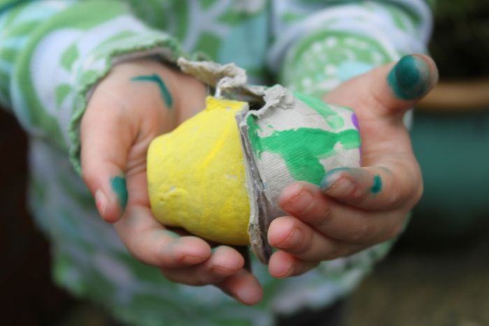 Špinavé ruky dieťaťa nesúce dve vaječné kartóny - Veľkonočné remeslá s vaječnou kartónovou krabičkou