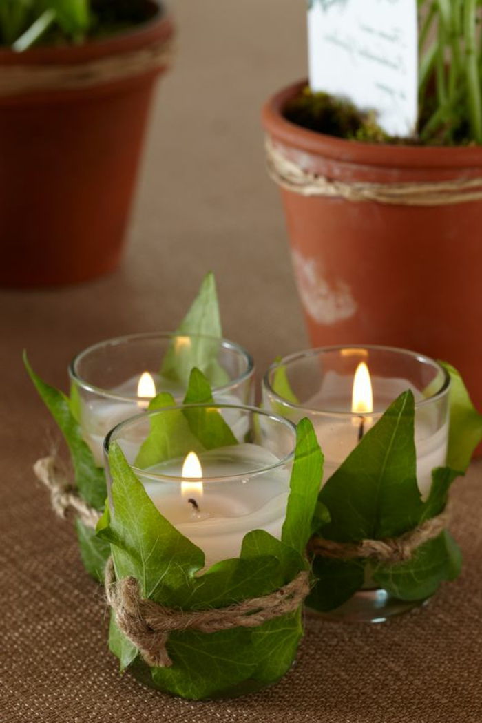 szklany świecznik ozdobiony zielonymi liśćmi, dekoracja diy, dekoracja stołu