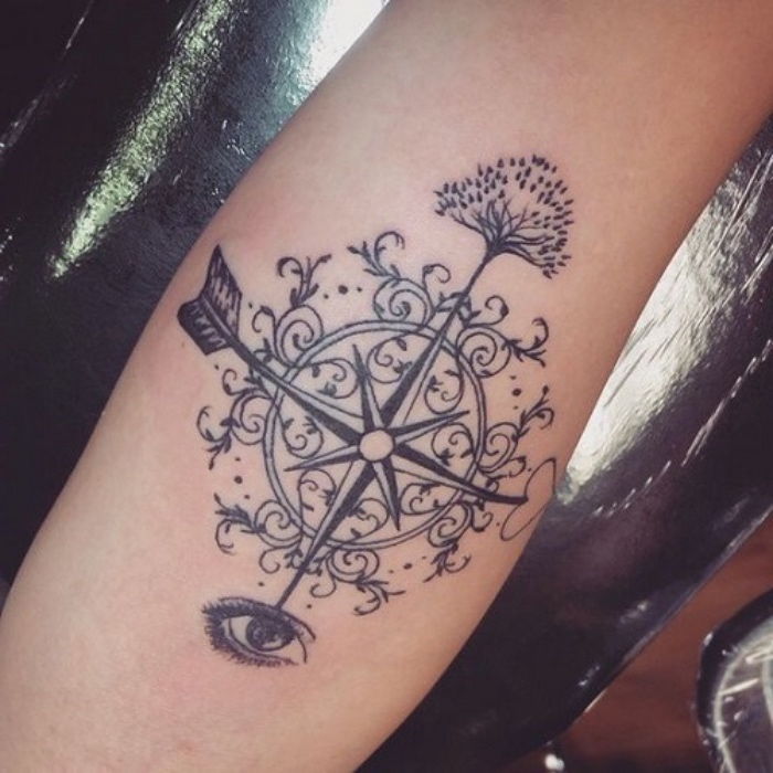 En annen ide for en svart tatovering med et tre og øyne og et svart kompass på en hånd