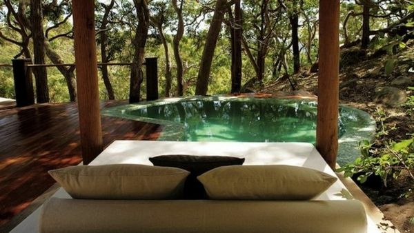 pohodlné-krásne-vonkajšie-posteľ-dva drevené stĺpy a rybníka