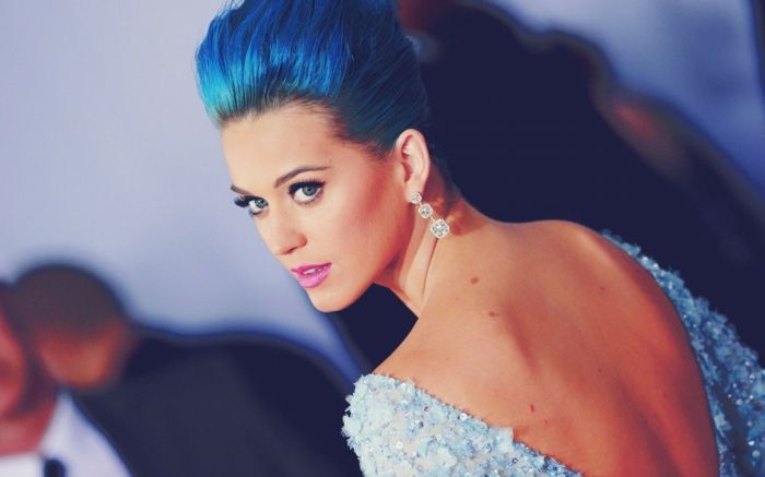 Katy Perry s modrými vlasmi, večerné šaty s holým chrbtom, fialové pery. pútavé náušnice