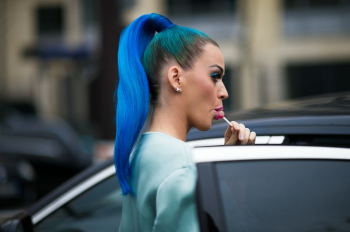 Katy Perry con coda di cavallo blu, peach rouge, ombretto blu, foto paparazzi, lecca-lecca