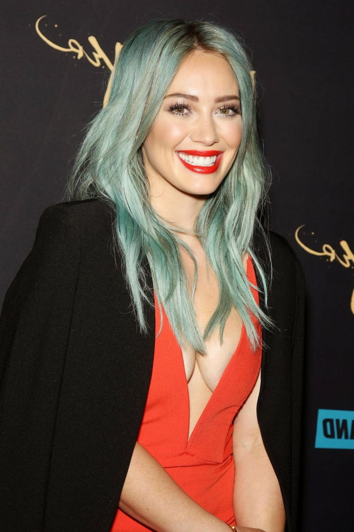 Hilary Duff con i capelli luminosi blu, labbra rosso brillante, Pozellanteint, grande vestito korallfarbenes Outfit- e blazer nero
