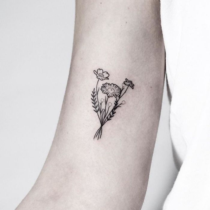 gėlių šakelė ant viršutinės rankos, moteris su maža tatuiruotė juoda ir pilka
