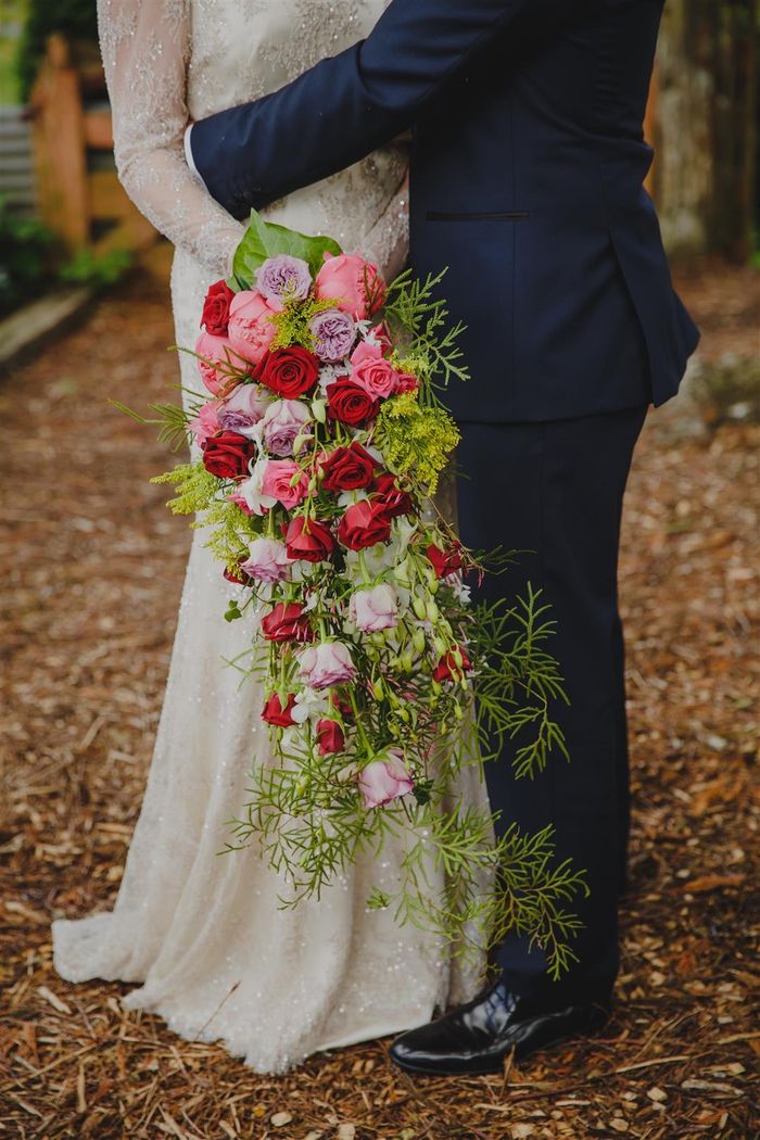 Bruiloft boeket vintage langwerpige boeket met rode en paarse rozen en veel groene planten