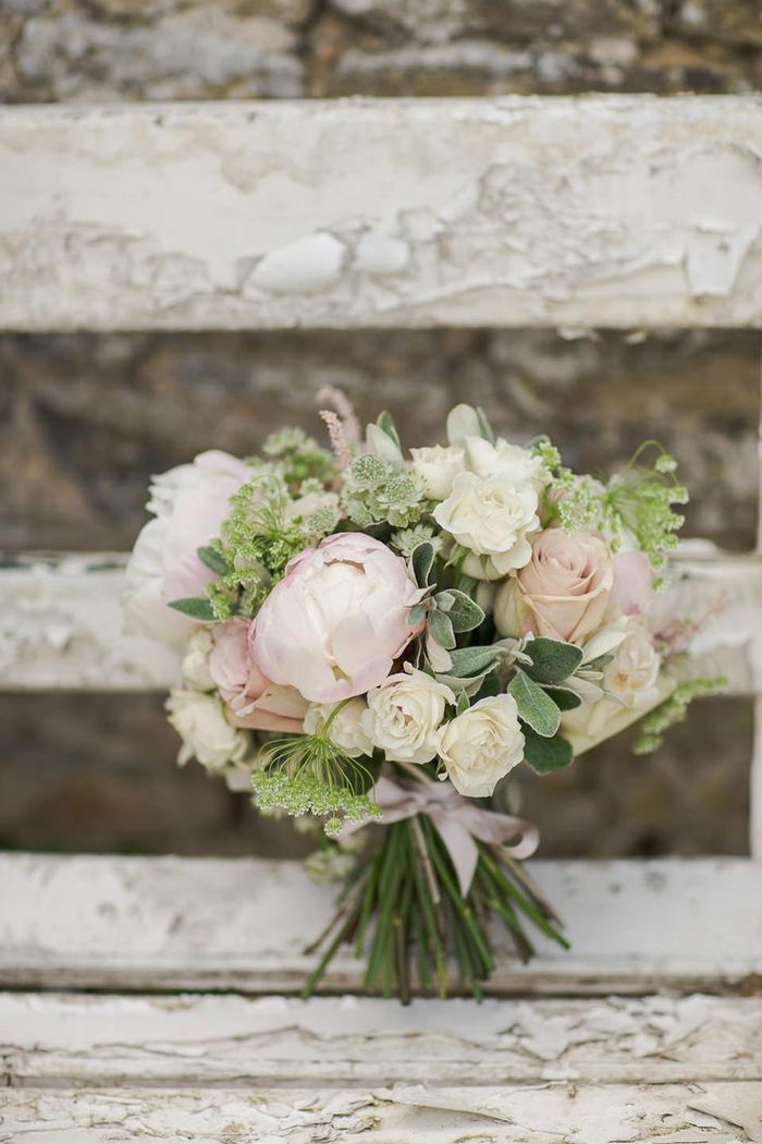 roze en witte bloemen met groen accent bruids boeket zomer op een vintage bankje