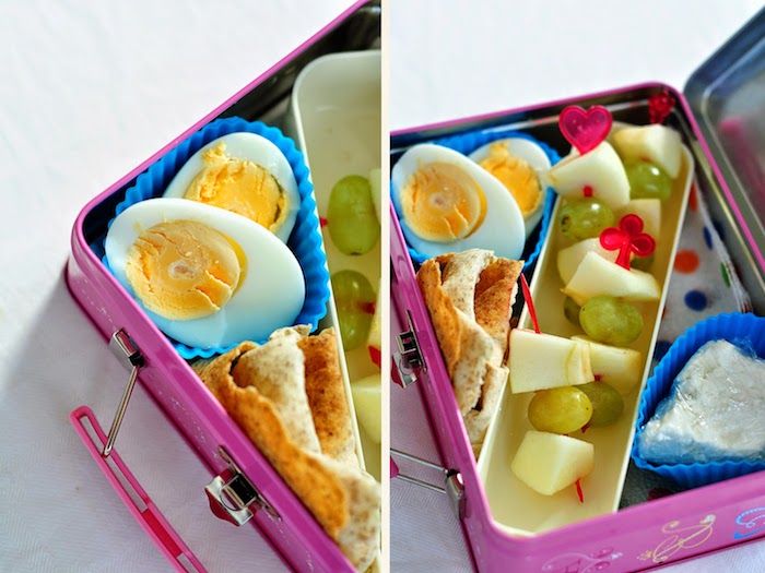 mor renkte küçük metal kutu, silikondan yapılmış muffin kalıpları, plastik sarma peynir, beyaz üzüm ve küçük elma parçaları ile meyve shashliks