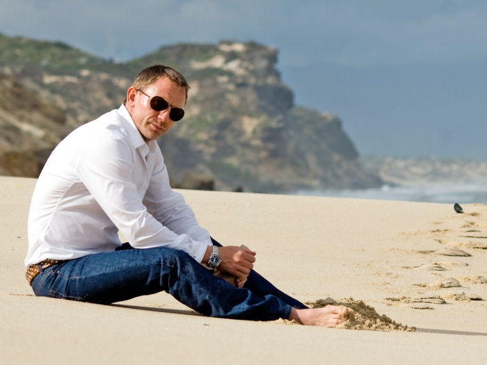 Daniel craig na praia jeans marrom cinto branco camisa óculos grande penteado relógio de pulso