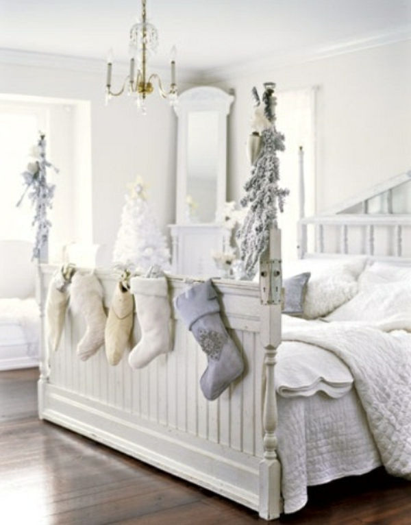 białe ozdoby świąteczne - skarpety wiszące na łóżku