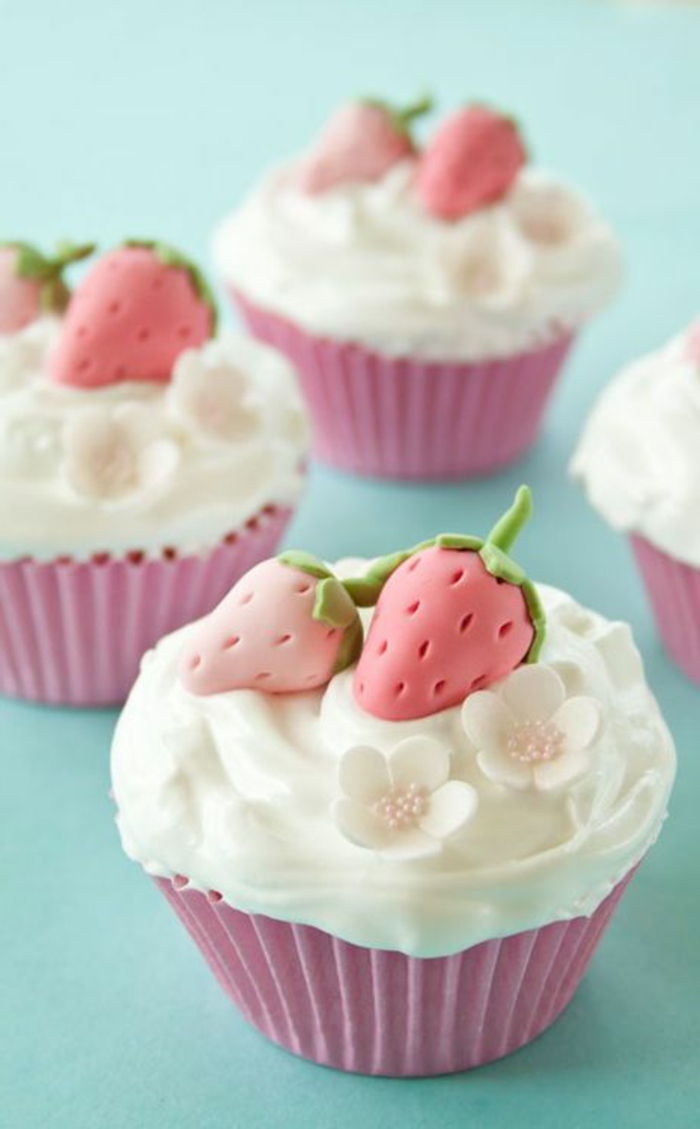 muffins met witte room, kleine bloemen en fondant-aardbeien