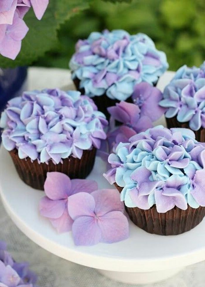 Muffins met bloemen van room in blauw en paars versieren