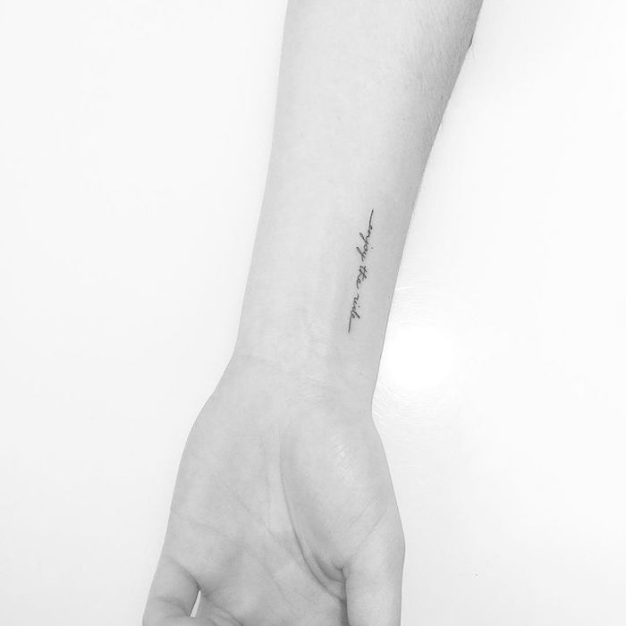 O mână de femeie cu un tatuaj negru puțin pe încheietura mâinii
