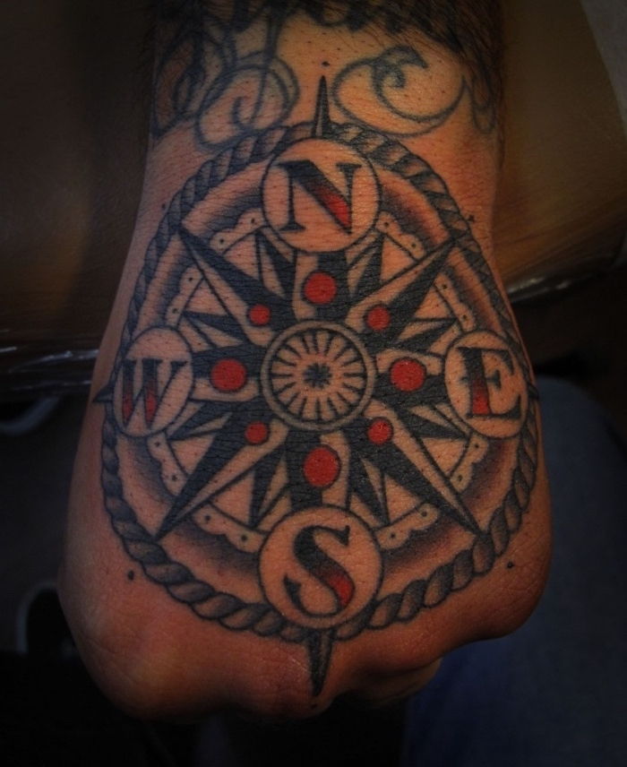 Her er en annen ide for en stor svart tatovering på hånden - en tatovering med kompass og røde prikker