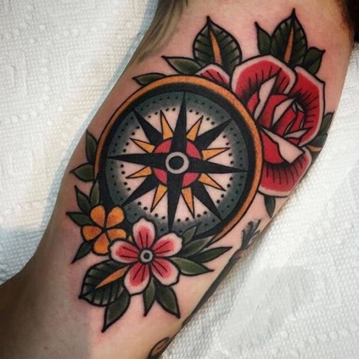 här är en idé för en liten vacker färgstark tatuering med en kompass med gula och röda blommor