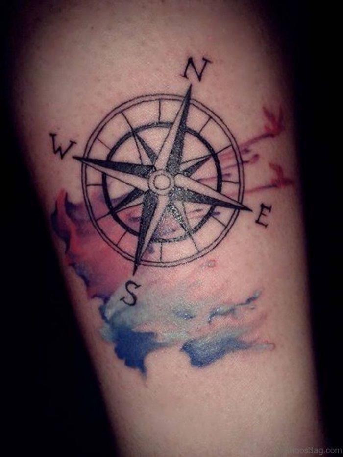 En ide for en tatovering med et stort svart kompass på hånden med noen fargerike farger
