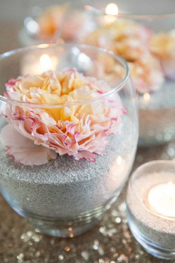 Stiklo vazos su smėliu ir gėlėmis, dekoruojamos stalo, žvakidės